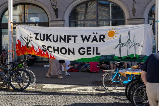News Bilder des Tages Augsburg, Bavaria, Germany - July 10, 2026: Demonstration by the climate justice movement Fridays for Future and Greenpeace in Augsburg. Under the nationwide slogan: Protect the climate, fire the rich,? the activists are protesting, among other things, against current gas infrastructure policy and planned gas drilling in Bavaria. Banners depicting a burning forest, wind turbines, and solar panels with the slogan: THE FUTURE WOULD BE AWESOME!? *** Demonstration der Klimaschutzbewegung Fridays for Future und GREENPEACE in Augsburg. Unter dem bundesweiten Motto: Klima schützen, Reiche entlassen, protestieren die Aktivisten unter anderem gegen die aktuelle Gas-Infrastrukturpolitik und geplante Gasbohrungen in Bayern. Banner mit bre