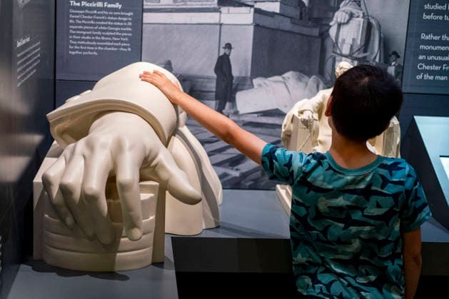 A visitor touches at a bust of former US president Abraham Lincoln s hand during a tour in the newly-remodeled undercroft beneath the Lincoln Memorial in Washington, DC on Friday, July 10, 2026. The new 15,000-square-foot exhibit showcases the massive concrete foundations that support the memorial while telling the story of how the Lincoln Memorial was designed and built.  WAP20260710340 BONNIExCASH