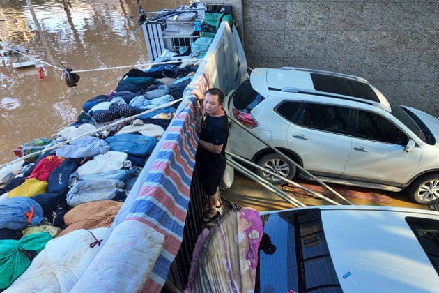 GUIGANG, CHINA - JULY 10: Residents stand guard near a makeshift flood barrier constructed from sandbags and vehicles to protect parked cars at the Shengshi Jiayuan residential complex on July 10, 2026 in Guigang, Guangxi Zhuang Autonomous Region of China. The local authorities beef up restoration efforts after torrential rains caused by Typhoon Maysak.  Copyright: xChinaxNewsxServicex 111653540911