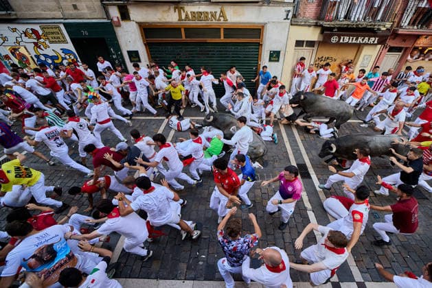 San Fermin Festival in Spain PAMPLONA, SPAIN - JULY 11: Participants wearing traditional white outfits and red scarves take part in the running with the bulls event, known as Encierro, during the San Fermin Festival in Pamplona, northern Spain, on July 11, 2026. The adrenaline-filled run covers an 875-meter stretch through the historic city center. Ruben Albarran Anadolu Pamplona Spain. Editorial use only. Please get in touch for any other usage.  Copyright: x2026xAnadoluxRubenxAlbarranx