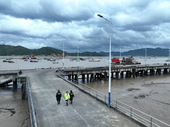 (260711) -- FUDING, July 11, 2026 -- An aerial drone photo taken on July 11, 2026 shows village officials and rescuers patrolling at a port in Shacheng Town of Fuding, southeast China s Fujian Province. Fujian has maintained its Level II typhoon emergency response and activated a Level III flood control emergency response as Typhoon Bavi nears China s east coast on Saturday. Local officials have implemented precautionary measures to prevent the Typhoon Bavi, including evacuating residents and inspecting geological hazard sites. Temporary shelters were fully stocked with supplies and medical resources. ) (SpotNews) CHINA-FUJIAN-FUDING-TYPHOON BAVI-PREVENTION (CN) JiangxKehong 