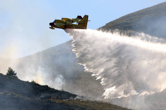Firefighters battle wildfires in western and southern Sicily SICILY, ITALY - JULY 11: A firefighting plane drops water to control wildfires in maquis areas across the western and southern parts of Sicily, Italy on July 11, 2026. Following initial overnight responses by ground crews with water tenders, helicopters and firefighting aircraft launched aerial operations at sunrise to bring the wind-driven fires under control. Alberto Lo Bianco Anadolu Sicily Italy. Editorial use only. Please get in touch for any other usage.  Copyright: x2026xAnadoluxAlbertoxLoxBiancox