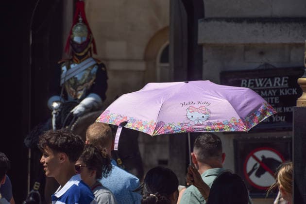 July 11, 2026, London, England, United Kingdom: Tourists shield from the sun under an umbrella at Horse Guards as the heatwave continues in the UK. London United Kingdom - ZUMAv130 20260711_zip_v130_021 Copyright: xVukxValcicx