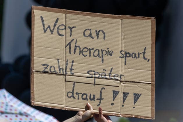 Demonstration für Solidarität statt Sozialabbau, Nürnberg, 11.07.2026 Demonstrantin hält ein handgeschriebenes Pappschild mit der Aufschrift Wer an Therapie spart, zahlt später drauf!!! . Das Schild richtet sich gegen Kürzungen im Gesundheits- und Sozialbereich. Nürnberg Bayern Deutschland *** Demonstration for Solidarity Instead of Social Cuts, Nuremberg, July 11, 2026. A demonstrator holds a handwritten cardboard sign reading, Those who cut funding for therapy will pay for it later. The sign protests cuts to health and social services. Nuremberg, Bavaria, Germany 20260711-1V9A5180-M4000
