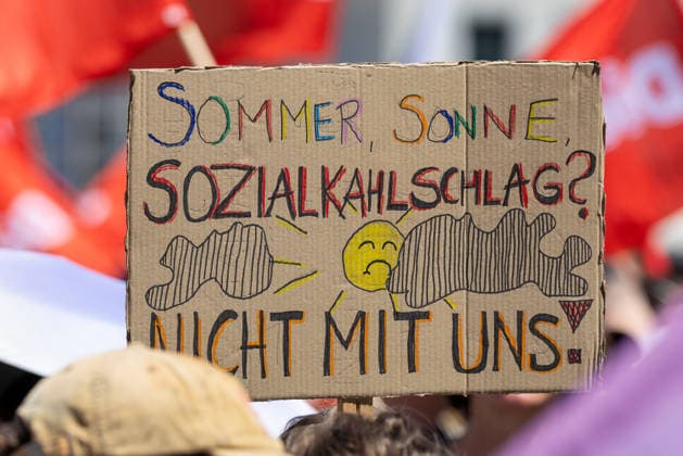 Demonstration für Solidarität statt Sozialabbau, Nürnberg, 11.07.2026 Handgeschriebenes Protestplakat mit der Aufschrift Sommer, Sonne, Sozialkahlschlag? Nicht mit uns! bei einer Demonstration des Bündnisses UNKÜRZBAR Mittelfranken. Im Hintergrund sind rote Gewerkschaftsfahnen zu sehen. Nürnberg Bayern Deutschland *** Demonstration for Solidarity Instead of Social Cuts, Nuremberg, July 11, 2026 Handwritten protest sign reading Summer, Sun, Social Cuts—Not on Our Watch at a demonstration organized by the UNKÜRZBAR Middle Franconia Alliance. Red union flags are visible in the background. Nuremberg, Bavaria, Germany 20260711-1V9A5177-M4000