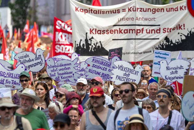 Demonstration für Solidarität statt Sozialabbau, Nürnberg, 11.07.2026 Demonstrationszug des Bündnisses UNKÜRZBAR Mittelfranken gegen das Reformpaket der Bundesregierung. Teilnehmer tragen Schilder mit Forderungen wie Völkerrecht statt Faustrecht , Rüstung runter und Klimaschutz statt Kriegsmanöver . Im Hintergrund ein Transparent mit der Aufschrift Klassenkampf und Streik . Nürnberg Bayern Deutschland *** Demonstration for Solidarity Instead of Social Cuts, Nuremberg, July 11, 2026. March organized by the UNKÜRZBAR Middle Franconia coalition against the federal government’s reform package. Participants carry signs with demands such as International Law Instead of the Law of the Jungle, Cut military spending and prioritize 20260711-1V9A5270-M4000