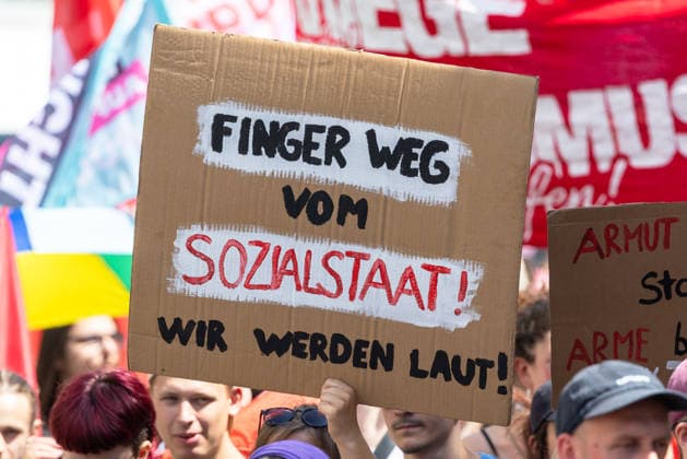 Demonstration für Solidarität statt Sozialabbau, Nürnberg, 11.07.2026 Demonstrantin hält ein Pappschild mit der Aufschrift Finger weg vom Sozialstaat! Wir werden laut! Anlass ist das Reformpaket der Bundesregierung, das das Bündnis UNKÜRZBAR Mittelfranken als Angriff auf den Sozialstaat und Arbeitnehmerrechte bezeichnet. Nürnberg Bayern Deutschland *** Demonstration for Solidarity Instead of Social Cuts, Nuremberg, July 11, 2026 A demonstrator holds a cardboard sign reading Hands off the welfare state—we’re making our voices heard. The occasion is the federal government’s reform package, which the UNKÜRZBAR Mittelfranken coalition describes as an attack on the welfare state and workers’ rights. Nuremberg, Bavaria, Germany 20260711-1V9A5278-M4000