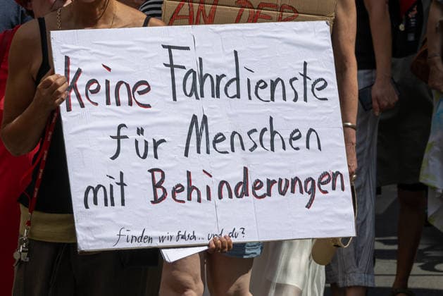 Demonstration für Solidarität statt Sozialabbau, Nürnberg, 11.07.2026 Demonstrantin hält ein handgeschriebenes Protestschild mit der Aufschrift Keine Fahrdienste für Menschen mit Behinderungen - finden wir falsch... und du? . Die Kundgebung des Bündnisses UNKÜRZBAR Mittelfranken richtet sich gegen das Reformpaket der Bundesregierung und den damit verbundenen Sozialabbau. Nürnberg Bayern Deutschland *** Demonstration for Solidarity Instead of Social Cuts, Nuremberg, July 11, 2026 A demonstrator holds a handwritten protest sign reading, We think it’s wrong that there are no transportation services for people with disabilities, and so do you. The rally organized by the UNKÜRZBAR Mittelfranken coalition is directed against the fede 20260711-1V9A5338-M4000