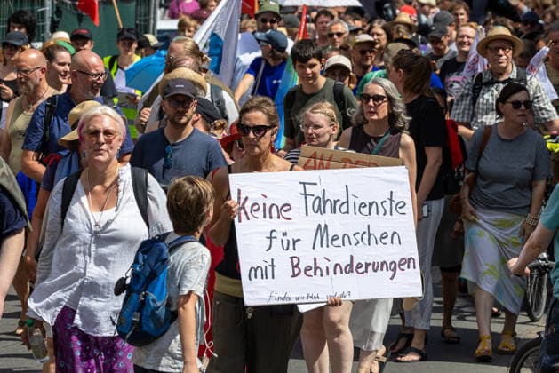 Demonstration für Solidarität statt Sozialabbau, Nürnberg, 11.07.2026 Eine Demonstrantin trägt ein handgeschriebenes Schild mit der Aufschrift Keine Fahrdienste für Menschen mit Behinderungen . Das Bündnis UNKÜRZBAR Mittelfranken demonstriert gegen das Reformpaket der Bundesregierung, das nach Ansicht der Organisatoren den Sozialstaat und die öffentliche Daseinsvorsorge gefährdet. Nürnberg Bayern Deutschland *** Demonstration for Solidarity Instead of Social Cuts, Nuremberg, July 11, 2026. A demonstrator carries a handwritten sign reading No Transportation Services for People with Disabilities. The UNKÜRZBAR Mittelfranken coalition is demonstrating against the federal government’s reform package, which, according to the organ 20260711-1V9A5339-M4000
