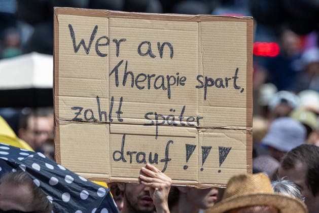 Demonstration für Solidarität statt Sozialabbau, Nürnberg, 11.07.2026 Demonstrant hält ein handgeschriebenes Pappschild mit der Aufschrift Wer an Therapie spart, zahlt später drauf!!! hoch. Das Bündnis UNKÜRZBAR Mittelfranken demonstriert gegen das Reformpaket der Bundesregierung und für den Erhalt sozialer Leistungen. Nürnberg Bayern Deutschland *** Demonstration for Solidarity Instead of Social Cuts, Nuremberg, July 11, 2026 A protester holds a handwritten cardboard sign reading, Those who cut funding for therapy will pay dearly later. The UNKÜRZBAR Mittelfranken alliance is demonstrating against the federal government’s reform package and in support of preserving social benefits. Nuremberg, Bavaria, Germany 20260711-1V9A5390-M4000