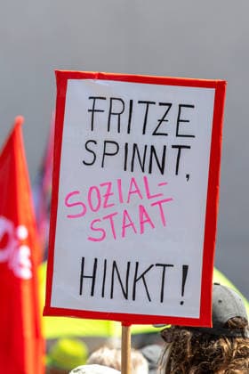 Demonstration für Solidarität statt Sozialabbau, Nürnberg, 11.07.2026 Protestschild mit der Aufschrift Fritze spinnt, Sozialstaat hinkt! bei einer Kundgebung gegen Sozialabbau. Im Hintergrund sind rote Gewerkschaftsfahnen zu sehen. Das Bündnis UNKÜRZBAR Mittelfranken demonstriert gegen das Reformpaket der Bundesregierung. Nürnberg Bayern Deutschland *** Demonstration for Solidarity Instead of Social Cuts, Nuremberg, July 11, 2026 Protest sign reading Fritze is crazy, the welfare state is lagging behind at a rally against welfare cuts. Red union flags are visible in the background. The UNKÜRZBAR Mittelfranken alliance is demonstrating against the federal government’s reform package. Nuremberg, Bavaria, Germany 20260711-1V9A5229-M4000