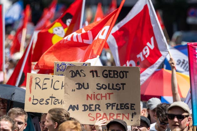 Demonstration für Solidarität statt Sozialabbau, Nürnberg, 11.07.2026 Demonstranten halten Schilder mit Aufschriften wie Das 11. Gebot: Du sollst nicht an der Pflege sparen! und Reich besteuern . Im Hintergrund wehen rote Gewerkschaftsfahnen, darunter Flaggen der ver.di. Das Bündnis UNKÜRZBAR Mittelfranken protestiert gegen das Reformpaket der Bundesregierung. Nürnberg Bayern Deutschland *** Demonstration for Solidarity Instead of Social Cuts, Nuremberg, July 11, 2026. Demonstrators hold signs with slogans such as The 11th Commandment: Thou Shalt Not Skimp on Care and Tax the Rich. In the background, red union flags are flying, including flags of ver.di. The UNKÜRZBAR Middle Franconia Alliance is protesting against the federa 20260711-1V9A5309-M4000
