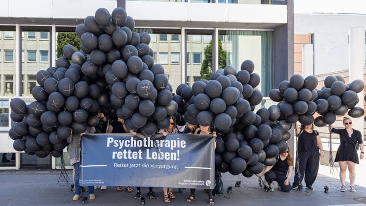 Demonstration für Solidarität statt Sozialabbau, Nürnberg, 11.07.2026 Aktivistinnen des Aktionsbündnis Psychotherapie e.V. halten bei der Kundgebung ein Banner mit der Aufschrift Psychotherapie rettet Leben! Rettet jetzt die Versorgung . Zahlreiche schwarze Luftballons mit Kreuzen symbolisieren fehlende Therapieplätze und Todesfälle. Nürnberg Bayern Deutschland *** Demonstration for Solidarity Instead of Social Cuts, Nuremberg, July 11, 2026 Activists from the Aktionsbündnis Psychotherapie e.V. hold a banner at the rally reading Psychotherapy Saves Lives—Save Access to Care Now. Numerous black balloons with crosses symbolize a lack of therapy slots and deaths. Nuremberg, Bavaria, Germany 20260711-286A1816-M4000