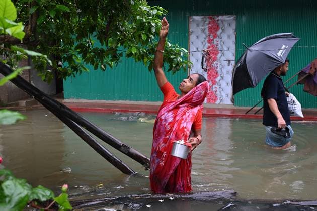 July 11, 2026, Satkania, Chattogram, Bangladesh: July 11, 2026, Satkania, Chattogram, Bangladesh: A woman collects flowers while standing in floodwater surrounding her home following days of relentless rainfall. Floods and landslides have affected more than 928,000 people across five districts in Chattogram Division. Satkania Bangladesh - ZUMAh178 20260711_zip_h178_028 Copyright: xMuhammadxAmdadxHossainx