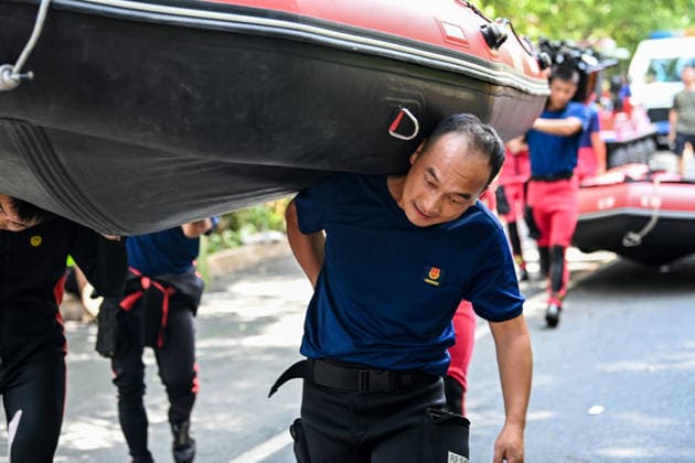 (260711) -- NANNING, July 11, 2026 -- Yang Dongsheng, a rescuer from Guilin fire and rescue bureau, carries an inflatable boat to the designated water area with his colleagues in Guigang, south China s Guangxi Zhuang Autonomous Region, July 10, 2026. Triggered by Typhoon Maysak, the tenth typhoon of the year, heavy downpours battered multiple areas in south China s Guangxi Zhuang Autonomous Region, resulting in a series of disasters. Various response forces have pooled their efforts, carrying out operations including rescue missions in remote mountainous areas, restoration of transport and power infrastructure, and silt clearing operations. ) CHINA-GUANGXI-TYPHOON-FLOOD-RESCUE (CN) CaoxYiming 