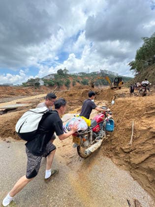 (260711) -- NANNING, July 11, 2026 -- Volunteers and villagers transport supplies on a road to Zhenlong Township of Hengzhou, south China s Guangxi Zhuang Autonomous Region, July 10, 2026. Triggered by Typhoon Maysak, the tenth typhoon of the year, heavy downpours battered multiple areas in south China s Guangxi Zhuang Autonomous Region, resulting in a series of disasters. Various response forces have pooled their efforts, carrying out operations including rescue missions in remote mountainous areas, restoration of transport and power infrastructure, and silt clearing operations. ) CHINA-GUANGXI-TYPHOON-FLOOD-RESCUE (CN) HuangxXiaobang 