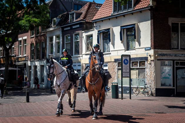 July 11, 2026, Schiedam, South Holland, Netherlands: 11 July 2026. Dutch police patrol on horseback while a demonstration and counter-demonstration happen nearby. In Schiedam, the Netherlands, a pro-asylum seeker demonstration promoted by Extinction Rebellion countered a demonstration called the Vrouwenmars tegen het AZC (Women s March Against the AZC) promoted by anti-asylum seeker centre groups. Both events took place in the center of Schiedam. Schiedam Netherlands - ZUMAp202 20260711_zip_p202_009 Copyright: xJamesxPetermeierx