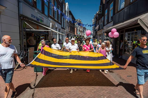 July 11, 2026, Schiedam, South Holland, Netherlands: 11 July 2026. Anti-asylum seeker center demonstrators carry a flag of the city of Schiedam during a protest march through the city. In Schiedam, the Netherlands, a pro-asylum seeker demonstration promoted by Extinction Rebellion countered a demonstration called the Vrouwenmars tegen het AZC (Women s March Against the AZC) promoted by anti-asylum seeker center groups. Both events took place in the center of Schiedam. Schiedam Netherlands - ZUMAp202 20260711_zip_p202_011 Copyright: xJamesxPetermeierx