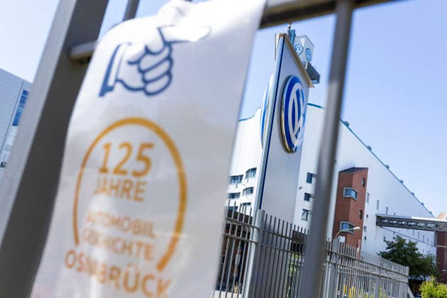 Schild 125 Jahre Automobil Geschichte Osnabrück am Zaun vor dem VW Werk in Osnabrück11.07.2026 Symbolbild VW Osnabrück *** Sign reading 125 Years of Automotive History in Osnabrück on the fence in front of the VW plant in Osnabrück, July 11, 2026. Stock photo: VW Osnabrück