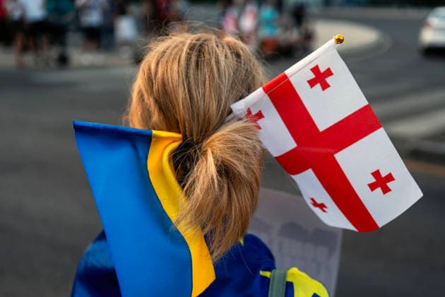 July 11, 2026, Tbilisi, Georgia: A protester with flags of Georgia and Ukraine in her hair and others march to mark 591st day of anti-government rally in Tbilisi, Georgia. Tbilisi Georgia - ZUMAz174 20260711_zip_z174_001 Copyright: xMoexZoyarix