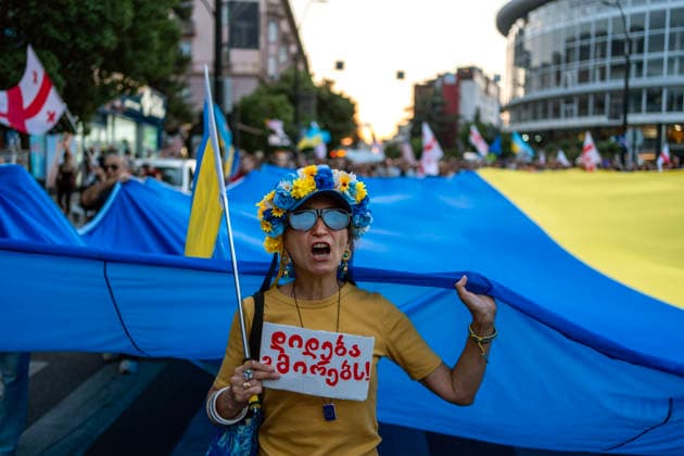 July 11, 2026, Tbilisi, Georgia: A woman chants as she and other protesters carry a large Ukrainian flag as they mark 591st day of anti-government rally in Tbilisi, Georgia. Tbilisi Georgia - ZUMAz174 20260711_zip_z174_002 Copyright: xMoexZoyarix