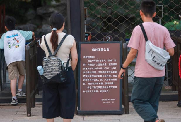 YANGZHOU, CHINA - JULY 11: Tourists check a closure notice at the entrance of the Slender West Lake scenic area on July 11, 2026 in Yangzhou, Jiangsu Province of China. Slender West Lake in Yangzhou has been temporarily closed as Typhoon Bavi barrels toward the country s eastern coast.  Copyright: xChinaxNewsxServicex 111653697399