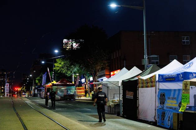 July 11, 2026, Toronto, On, Canada: A Toronto police officer walks past shut down vendor stalls after an active shooter at the Salsa on St. Clair event in Toronto, on Saturday, July 11, 2026. Toronto Canada  - ZUMAc35_ 20260711_zaf_c35_036 Copyright: xKeitoxNewmanx