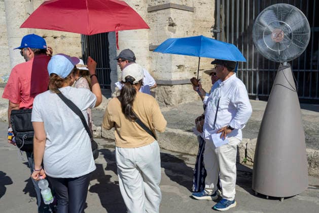 July 11, 2026, Rome, Italy: Tourists shield themselves from the sun with large umbrellas and seek relief from the heat in front of a fan before entering the Colosseum during the hottest hours of the day when Italy is trapped in the grip of the July heat in Rome. After the storms of the past few days, a new wave of intense heat is expected across Italy. The subtropical anticyclone will once again dominate the Italian weather landscape, paving the way for a new phase of intense heat destined to affect much of the country for the entire next week. Rome Italy  - ZUMAv147 20260711_zip_v147_005 Copyright: xMarcelloxValerix