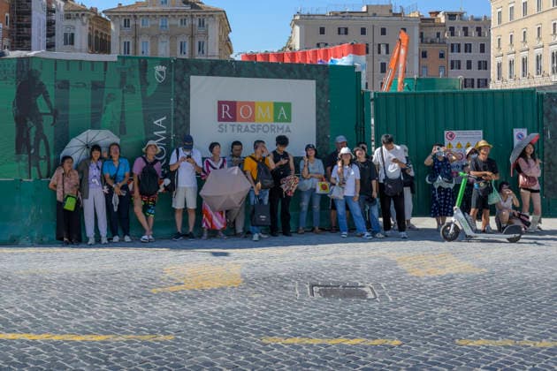 July 11, 2026, Rome, Italy: Tourists seek relief in the shade of the barriers hiding the construction work in Piazza Venezia during the hottest hours of the day when Italy is trapped in the grip of the July heat in Rome. After the storms of the past few days, a new wave of intense heat is expected across Italy. The subtropical anticyclone will once again dominate the Italian weather landscape, paving the way for a new phase of intense heat destined to affect much of the country for the entire next week. Rome Italy  - ZUMAv147 20260711_zip_v147_004 Copyright: xMarcelloxValerix