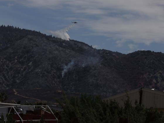 (260712) -- ANTELOPE VALLEY, July 12, 2026 -- A fire-fighting helicopter drops water on the forest fire in Antelope Valley, Los Angeles County, California, the United States, July 11, 2026. A wildfire burning in U.S. Southern California exploded to nearly 2,700 acres (about 10.9 square kilometers) Saturday, forcing evacuations amid dangerous heat wave. (Photo by Xinhua) U.S.-CALIFORNIA-LOS ANGELES COUNTY-WILDFIRE QiuxChen 