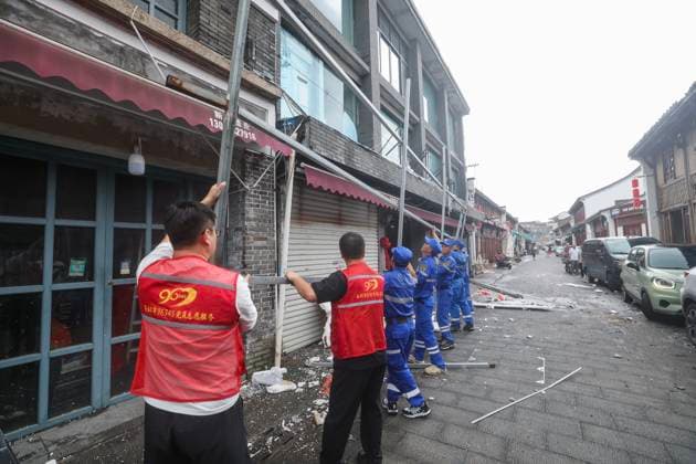 (260712) -- TAIZHOU, July 12, 2026 -- Volunteers and emergency workers remove an iron signboard frame blown down by strong winds in Yuhuan of Taizhou City, east China s Zhejiang Province, July 12, 2026. Typhoon Bavi, the ninth typhoon of the year, landed on the coast of east China s Zhejiang Province at around 11:20 p.m. Saturday, according to the Zhejiang provincial meteorological observatory. The typhoon, with the maximum wind force at its center reaching 40 meters per second when landing, first churned ashore at Yuhuan City, a county-level city administered by the city of Taizhou, before making a second landfall in Yueqing City under the city of Wenzhou at around midnight. After landfall, the typhoon is expected to continue moving n 