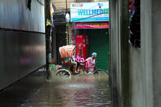 July 12, 2026, Dhaka, Dhaka, Bangladesh: A rickshaw puller pedals through a waterlogged street while carrying passengers during heavy monsoon rainfall in Dhaka, Bangladesh. Persistent downpours have inundated large parts of the capital, disrupting daily life and transportation, forcing residents to continue their routines despite widespread flooding. Dhaka Bangladesh  - ZUMAk174 20260712_zip_k174_003 Copyright: xSyedxMahabubulxKaderx