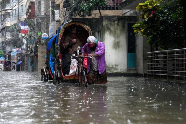 July 12, 2026, Dhaka, Dhaka, Bangladesh: A rickshaw puller pedals through a waterlogged street while carrying passengers during heavy monsoon rainfall in Dhaka, Bangladesh. Persistent downpours have inundated large parts of the capital, disrupting daily life and transportation, forcing residents to continue their routines despite widespread flooding. Dhaka Bangladesh  - ZUMAk174 20260712_zip_k174_011 Copyright: xSyedxMahabubulxKaderx