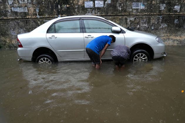 July 12, 2026, Dhaka, Dhaka, Bangladesh: Two men inspect a car stranded in a waterlogged street following heavy monsoon rainfall in Dhaka, Bangladesh. Persistent downpours have inundated large parts of the capital, disrupting transportation and daily life as widespread flooding affects roads and vehicles. Dhaka Bangladesh  - ZUMAk174 20260712_zip_k174_014 Copyright: xSyedxMahabubulxKaderx