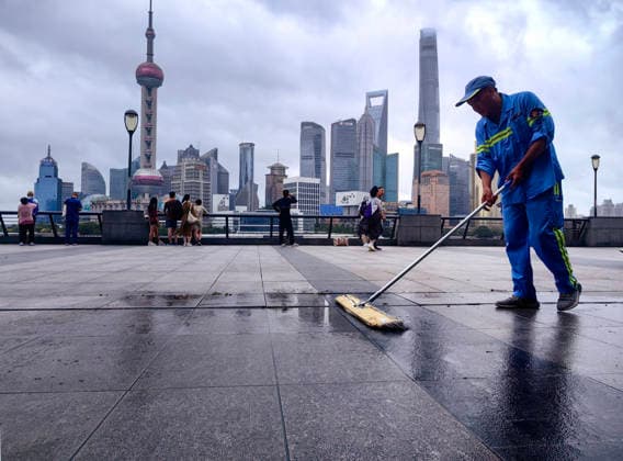 SHANGHAI, CHINA - JULY 12: Sanitation worker removes accumulated water on the Bund as Typhoon Bavi brings strong wind to city Shanghai on July 12, 2026 in Shanghai, China. The number of tourists decreased significantly due to the severe weather conditions.  Copyright: xVCGx 111653809692