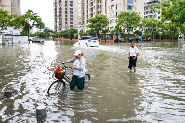 (260712) -- HANGZHOU, July 12, 2026 -- Citizens walk through an inundated road in Yueqing City, east China s Zhejiang Province, July 12, 2026. Typhoon Bavi, the ninth typhoon of the year, landed on the coast of east China s Zhejiang Province at around 11:20 p.m. Saturday, according to the Zhejiang provincial meteorological observatory. The typhoon, with the maximum wind force at its center reaching 40 meters per second when landing, first churned ashore at Yuhuan City, a county-level city administered by the city of Taizhou, before making a second landfall in Yueqing City under the city of Wenzhou at around midnight. After landfall, the typhoon is expected to continue moving northwestward while weakening. ) FOCUS Typhoon Bavi makes landf 