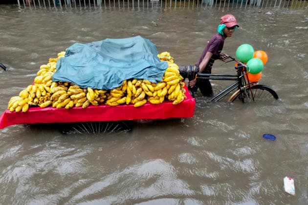 July 12, 2026, Dhaka, Dhaka, Bangladesh: DHAKA, Bangladesh, July 12, 2026 Ã¢â‚¬ Overnight heavy rainfall triggered widespread waterlogging across Dhaka on Sunday, disrupting daily life and causing severe hardship for residents...Several low-lying areas of the capital were submerged under knee- to waist-deep water, forcing commuters, schoolchildren, office workers and daily wage earners to wade through flooded streets. In several neighborhoods, mothers were seen carrying their children, while parents guided students by hand through waterlogged roads...The persistent rainfall caused severe traffic congestion on major roads across the capital, leaving many commuters stranded for hours and delaying travel. According to local residents, inade  - ZUMAk185 20260712_zip_k185_005 Copyright: xRubelxKarmakerx