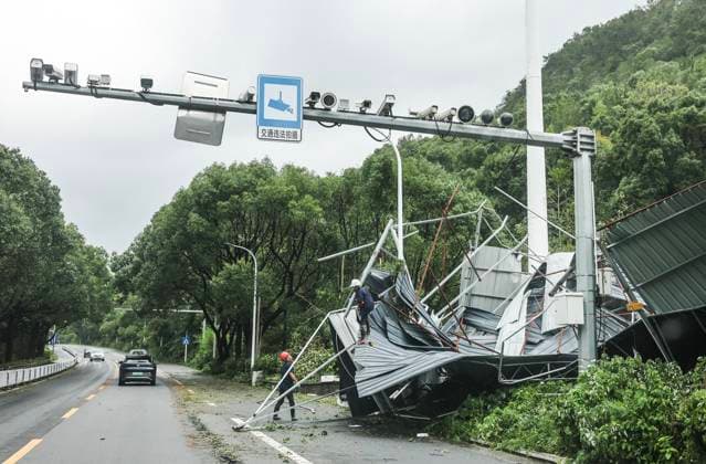 (260712) -- BEIJING, July 12, 2026 -- Workers clear a destroyed building blown down by strong winds beside a highway from Wenling to Yuhuan in east China s Zhejiang Province, July 12, 2026. Typhoon Bavi, the ninth typhoon of the year, landed on the coast of east China s Zhejiang Province at around 11:20 p.m. Saturday, according to the Zhejiang provincial meteorological observatory. The typhoon, with the maximum wind force at its center reaching 40 meters per second when landing, first churned ashore at Yuhuan City, a county-level city administered by the city of Taizhou, before making a second landfall in Yueqing City under the city of Wenzhou at around midnight. After landfall, the typhoon is expected to continue moving northwestwar 
