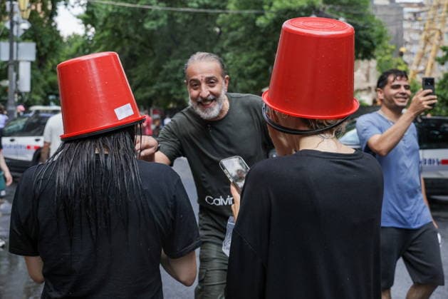 ARMENIA, YEREVAN - JULY 12, 2026: Women wear buckets on their heads as citizens enjoy dousing each other during the traditional feast of Vardavar celebrated by the Armenian Apostolic Church to mark the Transfiguration of Christ. Alexander Patrin TASS  94970928