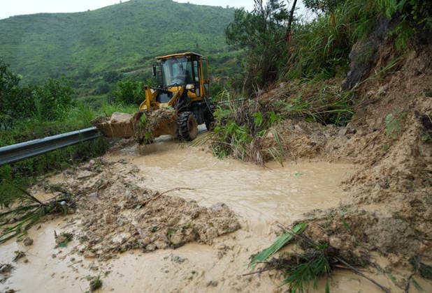 (260712) -- BEIJING, July 12, 2026 -- A staff member drives an excavator to clear a road blocked by small-scale landslides in a village in Qiangtian County, Lishui City, east China s Zhejiang Province, July 12, 2026. Chinese authorities have stepped up flood control and disaster relief efforts as Typhoon Bavi continued to affect large parts of the country on Sunday. Typhoon Bavi, the ninth typhoon of the year, made successive landfalls along the coast of east China s Zhejiang Province late Saturday before moving inland. It is expected to move northwest while gradually weakening. ) CHINA-TYPHOON BAVI-AFTERMATHS (CN) HanxChuanhao 