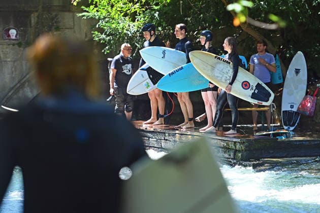 Wetterbild vom 12.07.2026 Surfer am Eisbach in Muenchen Hochbetrieb bei bestem Sommerwetter an der beruehmten Eisbachwelle im Englischen Garten in Muenchen. *** Weather photo from July 12, 2026: Surfers on the Eisbach in Munich. The famous Eisbach wave in Munich’s English Garden is bustling with activity amid perfect summer weather.