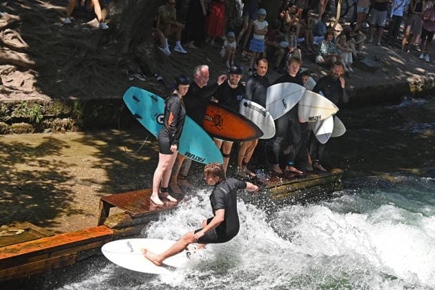 Wetterbild vom 12.07.2026 Surfer am Eisbach in Muenchen Hochbetrieb bei bestem Sommerwetter an der beruehmten Eisbachwelle im Englischen Garten in Muenchen. *** Weather photo from July 12, 2026: Surfers on the Eisbach in Munich. The famous Eisbach wave in Munich’s English Garden is bustling with activity amid perfect summer weather.