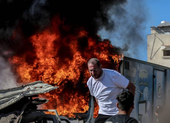 Israeli attacks on Gaza continue in violation of the ceasefire GAZA CITY, GAZA , PALESTINE - JULY 12: Palestinians rush as flame and thick smoke rise from a vehicle and destruction on Al-Sinaa (Industrial) Street in western Gaza City on July 12, 2026, after the Israeli military targeted several buildings using unmanned aerial vehicles (UAVs). The drone-fired missiles caused significant damage and structural ruin across the residential and commercial area. Saeed M. M. T. Jaras Anadolu Gaza City Gaza. Editorial use only. Please get in touch for any other usage.  Copyright: x2026xAnadoluxSaeedxM.xM.xT.xJarasx