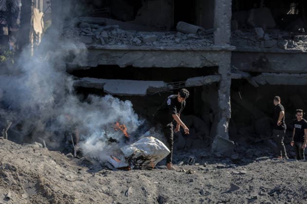 Israeli attacks on Gaza continue in violation of the ceasefire GAZA CITY, GAZA , PALESTINE - JULY 12: Palestinians rush as smoke rises among rubble and destruction on Al-Sinaa (Industrial) Street in western Gaza City on July 12, 2026, after the Israeli military targeted several buildings using unmanned aerial vehicles (UAVs). The drone-fired missiles caused significant damage and structural ruin across the residential and commercial area. Saeed M. M. T. Jaras Anadolu Gaza City Gaza. Editorial use only. Please get in touch for any other usage.  Copyright: x2026xAnadoluxSaeedxM.xM.xT.xJarasx