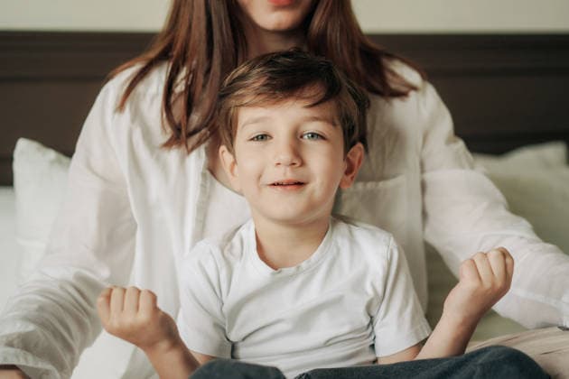 Ein lächelnder Junge sitzt auf dem Schoß seiner Mutter im Bett und teilt einen warmen Familienmoment. A smiling young boy sits on his mother s lap in bed, sharing a warm family moment. (License=RF) ,model released, Symbolfoto Copyright: xZoonar.com TITOVAxILONAx 25277696 ,model released, Symbolfoto ,property released