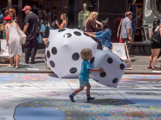 July 12, 2026, New York, New York, USA: Playing with giant dice on monumental size Goose Game ( le Jen de l Ole ) at New York City s largest public Bastille Day celebration hosted by L Alliance New York took place on Madison Ave with a massive block.party with gourmet and lifestyle vendors, classic Citroens, a dog parade and a .monumental street Goose Game. New York USA - ZUMAh156 20260712_znp_h156_009 Copyright: xMiloxHessx