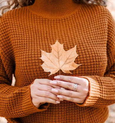Farbe des Jahres 2024: Peach Fuzz. Eine junge, fröhliche Frau sammelt Blätter in einem herbstlichen Wald Color of the year 2024: Peach Fuzz.Young happy woman in red sweater gathering leaves in autumn forest (License=RF) ,model released, Symbolfoto Copyright: xZoonar.com IlonaxShorokhovax 25280203 ,model released, Symbolfoto ,property released