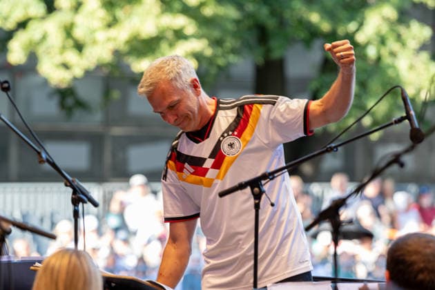 Klassik!Picknick mit dem Beethoven Orchester auf dem Kunst!Rasen Bonn Generalmusikdirektor Dirk KAFTAN im Deutschland Trikot - Das Beethoven Orchester Bonn unter der Leitung von Generalmusikdirektor Dirk KAFTAN beim Open-Air-Konzert KLASSIK!PICKNICK auf dem Kunst!Rasen Bonn-Gronau. Das Sommerprogramm steht unter dem Motto Fußball - passend zur WM 2026. Die Konzertreihe findet am Rande der Rheinaue am Bonner Rheinufer statt. Bonn Gronau Nordrhein-Westfalen Deutschland *** Classical Picnic with the Beethoven Orchestra on the Kunst Rasen in Bonn; General Music Director Dirk KAFTAN in the Germany jersey. The Beethoven Orchestra Bonn, conducted by General Music Director Dirk KAFTAN, at the open-air concert Classical Picnic on the Kunst Rasen Copyright: xMarcxJohnx