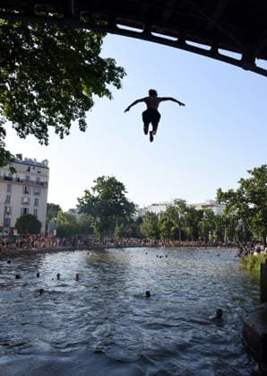 Heatwave Hits at Canal Saint-Martin - Paris Tourists and parisians cool themselves at Canal Saint-Martin as a Heatwave hits in Paris, 40°C expected towards temperature records in France on July 12, 2026. Photo by Alain Apaydin ABACAPRESS.COM Paris France  Copyright: xApaydinxAlain ABACAx