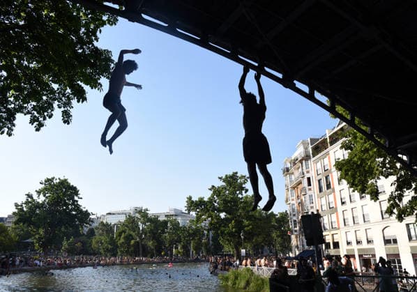 Heatwave Hits at Canal Saint-Martin - Paris Tourists and parisians cool themselves at Canal Saint-Martin as a Heatwave hits in Paris, 40°C expected towards temperature records in France on July 12, 2026. Photo by Alain Apaydin ABACAPRESS.COM Paris France  Copyright: xApaydinxAlain ABACAx